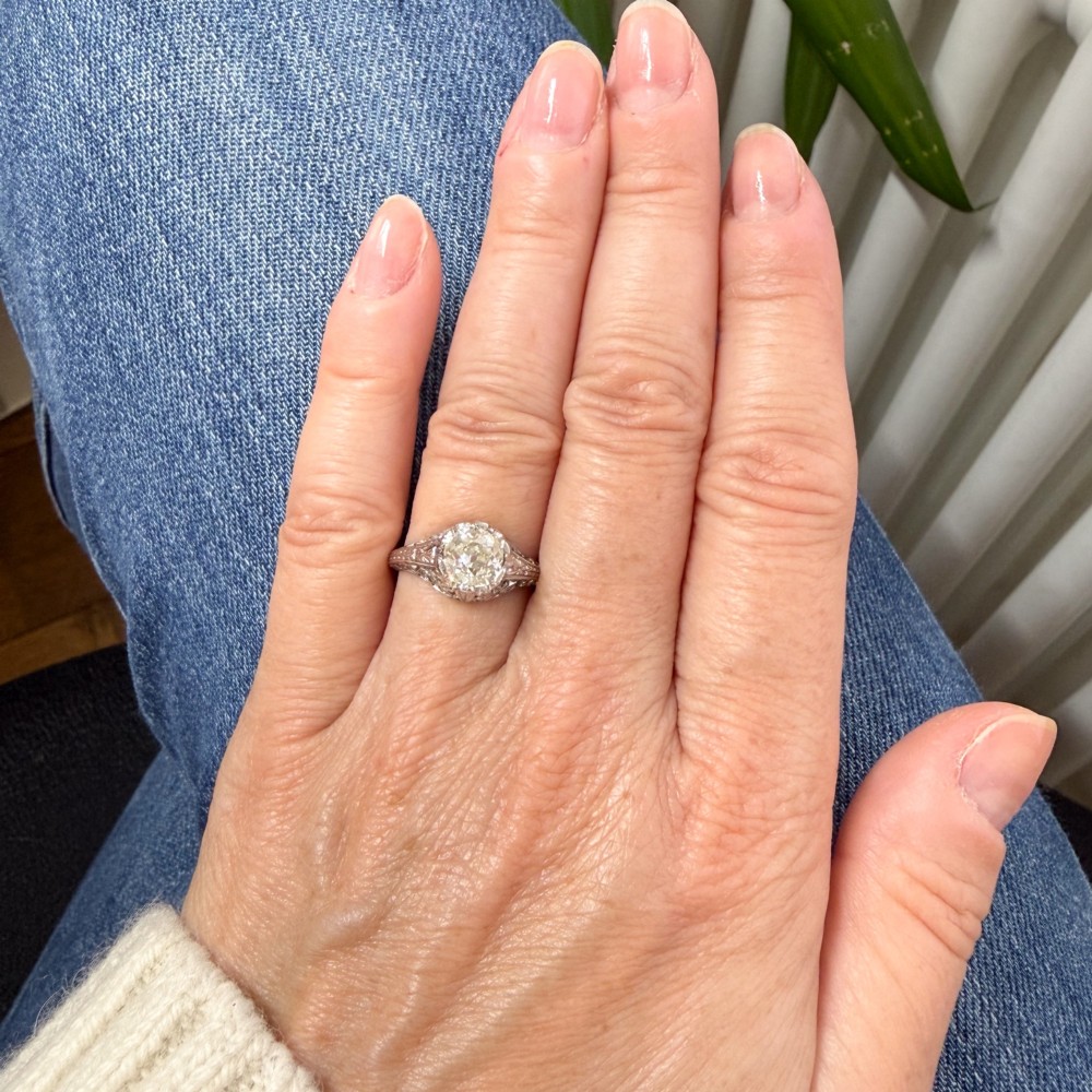 An Art Deco solitaire ring featuring an old European cut diamond set in an intricately carved filigree silver-coloured band. View VII