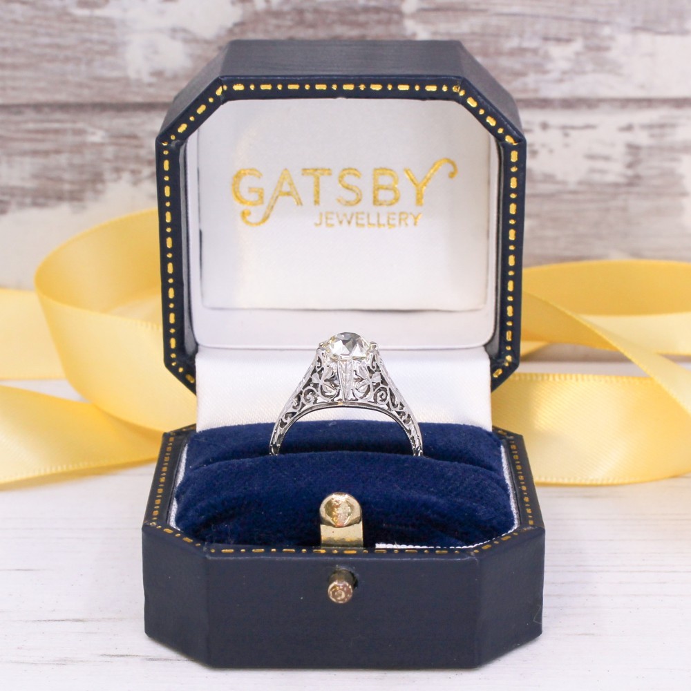 An Art Deco solitaire ring featuring an old European cut diamond set in an intricately carved filigree silver-coloured band. View IX