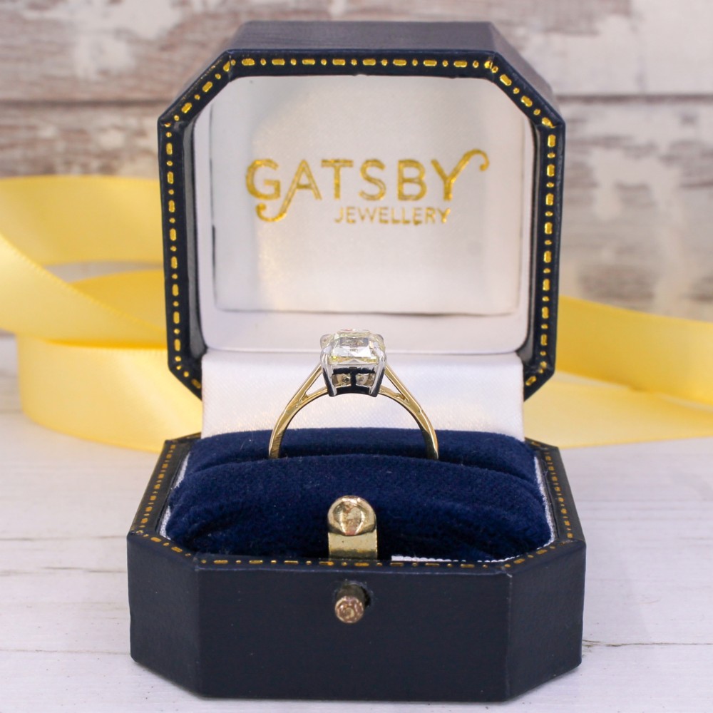 A vintage solitaire engagement ring featuring an old cut cushion diamond held in platinum claws on a tapered yellow gold band. View IX