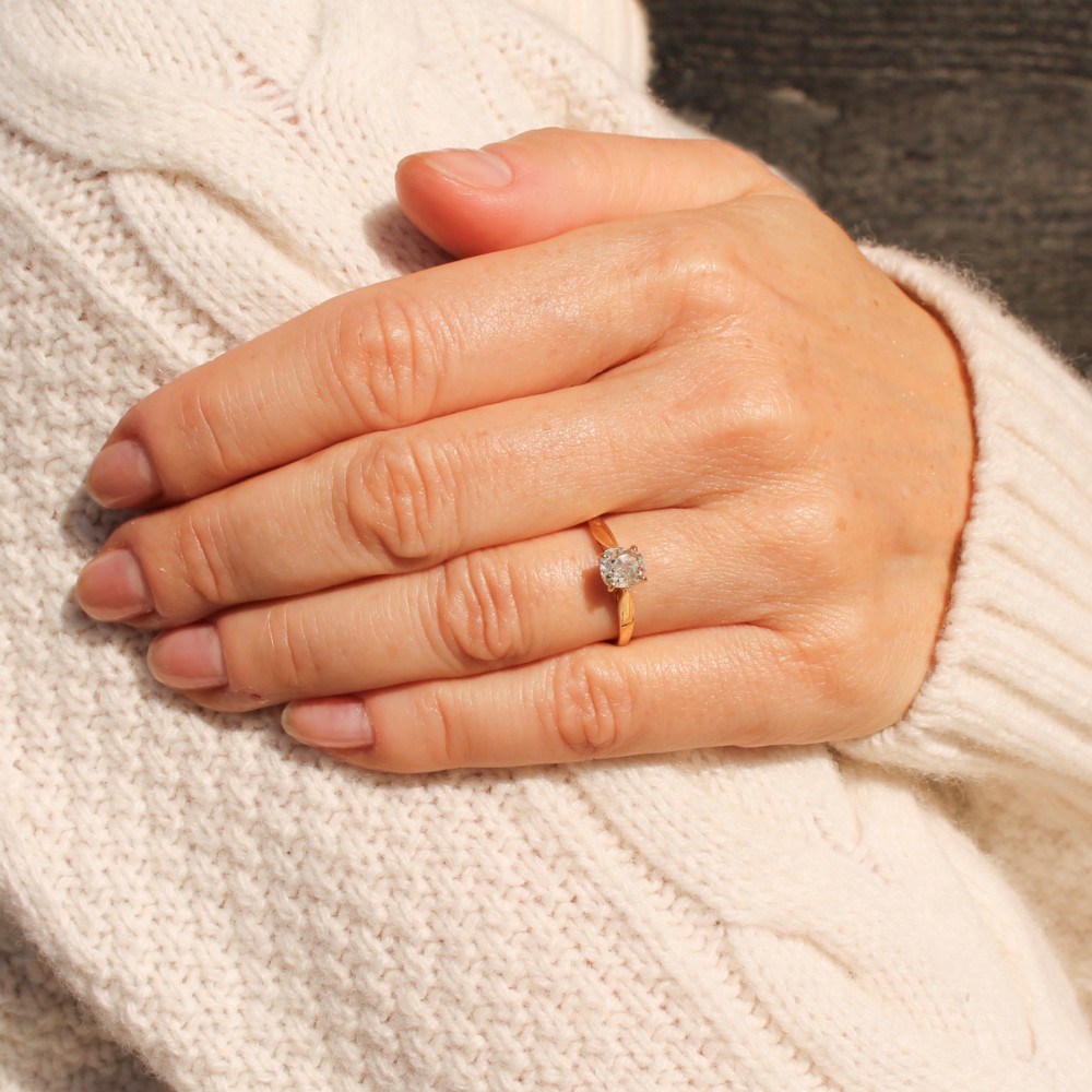 An Edwardian yellow gold solitaire ring featuring a claw-set old cut diamond on a slender band. View VII