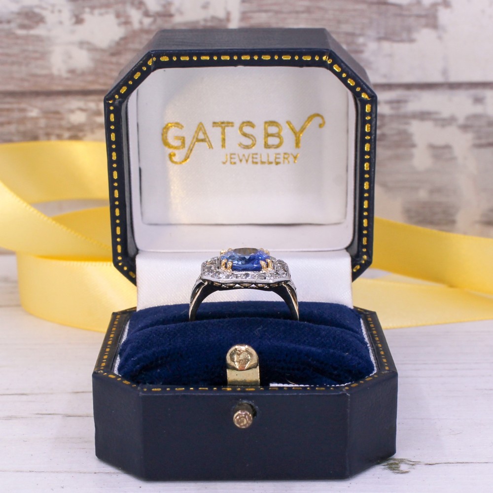 An antique Edwardian cluster ring featuring a central cushion-cut blue Ceylon sapphire surrounded by a halo of diamonds set in platinum and yellow gold. View IX