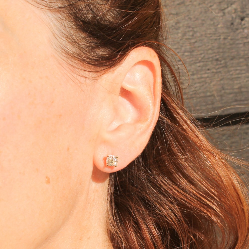 A pair of 18k yellow gold stud earrings featuring claw-set old mine cut cushion diamonds. View VI