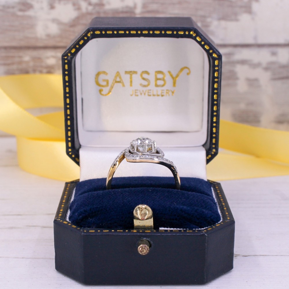 An antique Edwardian diamond ring featuring a central old cut diamond wrapped in a platinum-faced swirl setting studded with small accent diamonds on a yellow gold band. View VIII