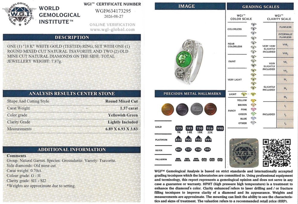 A white metal ring featuring a central round green tsavorite garnet flanked by two old cut diamonds set within a carved band. View VIII