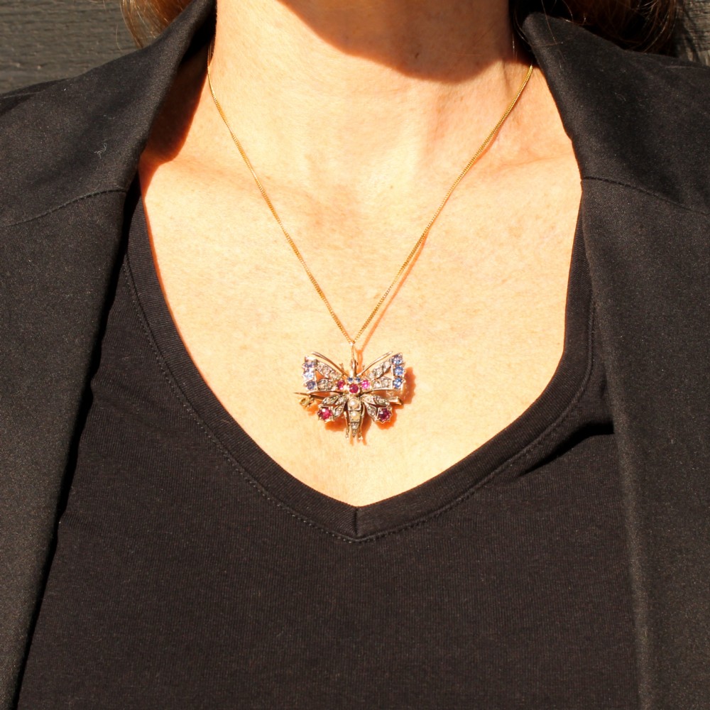 A Victorian butterfly brooch set with rubies, sapphires, diamonds, and natural pearls in silver and gold. View III
