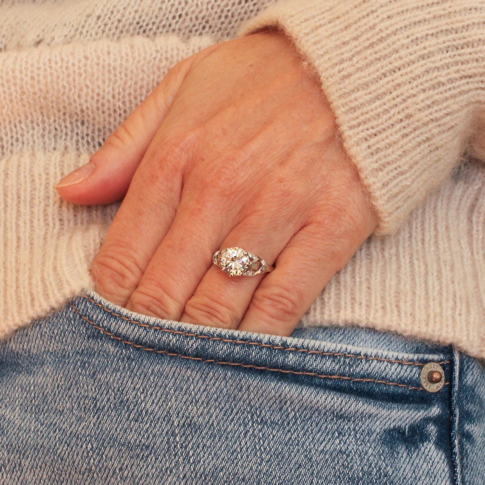 A vintage mid-century platinum engagement ring featuring a central round brilliant cut diamond flanked by baguette and round accent stones. View VII