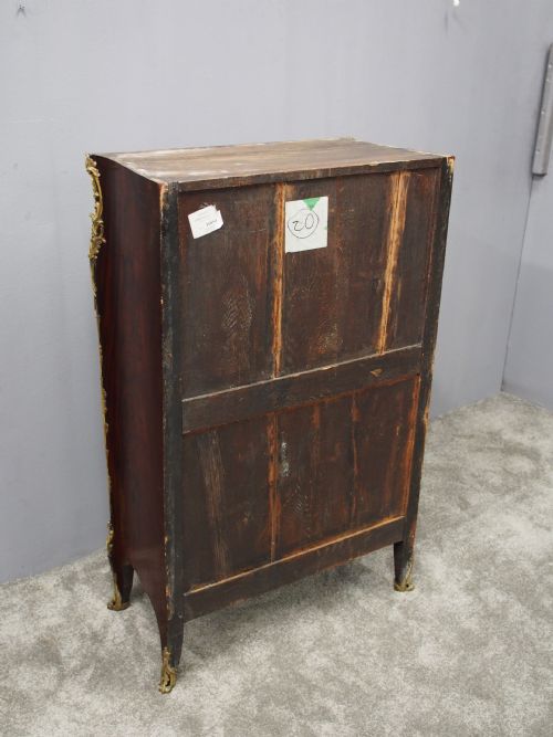 fig 1. A Louis XV style kingwood cabinet featuring geometric parquetry veneering, a red-toned marble top, two upper cabinet doors, three lower drawers, and gilt-bronze ormolu mounts.