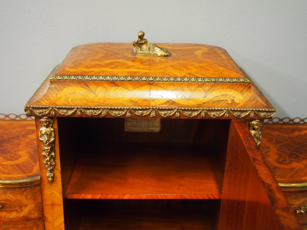 A French Rococo Revival ladies writing desk featuring intricate wood marquetry, gilt-bronze mounts, cabriole legs, and a central cabinet door set with a hand-painted porcelain plaque. View VI