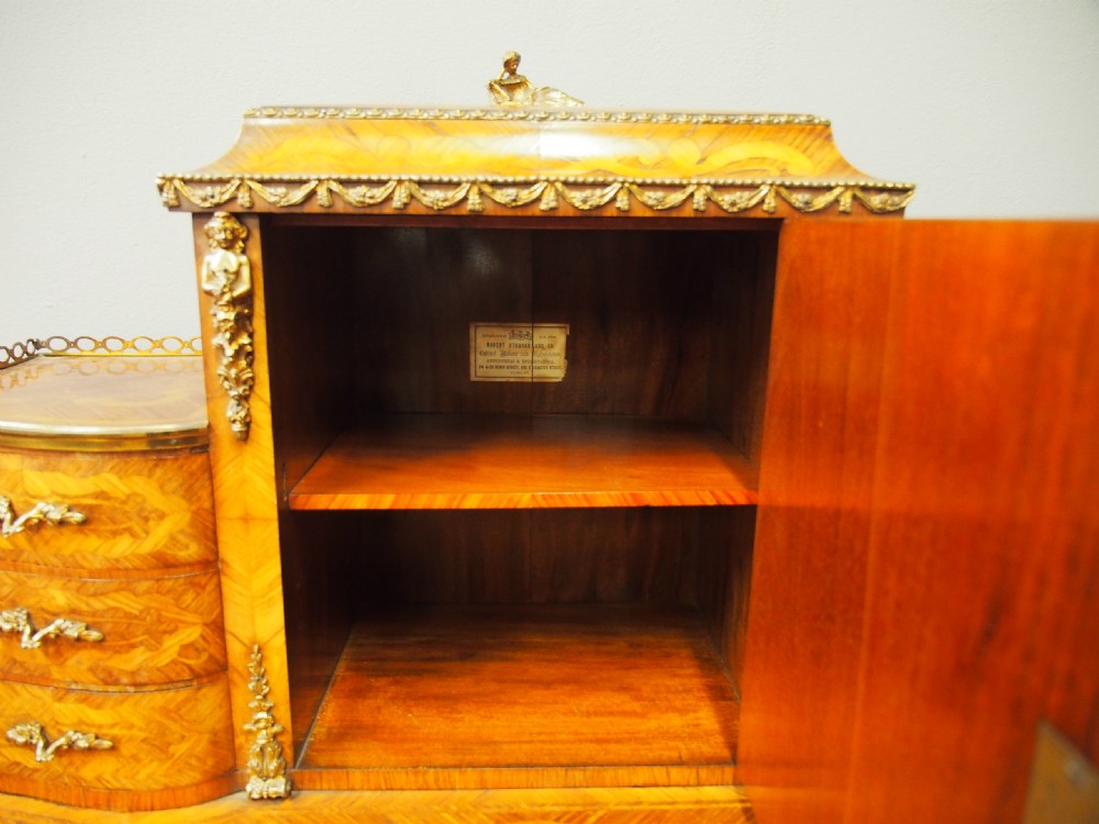 A French Rococo Revival ladies writing desk featuring intricate wood marquetry, gilt-bronze mounts, cabriole legs, and a central cabinet door set with a hand-painted porcelain plaque. View VIII