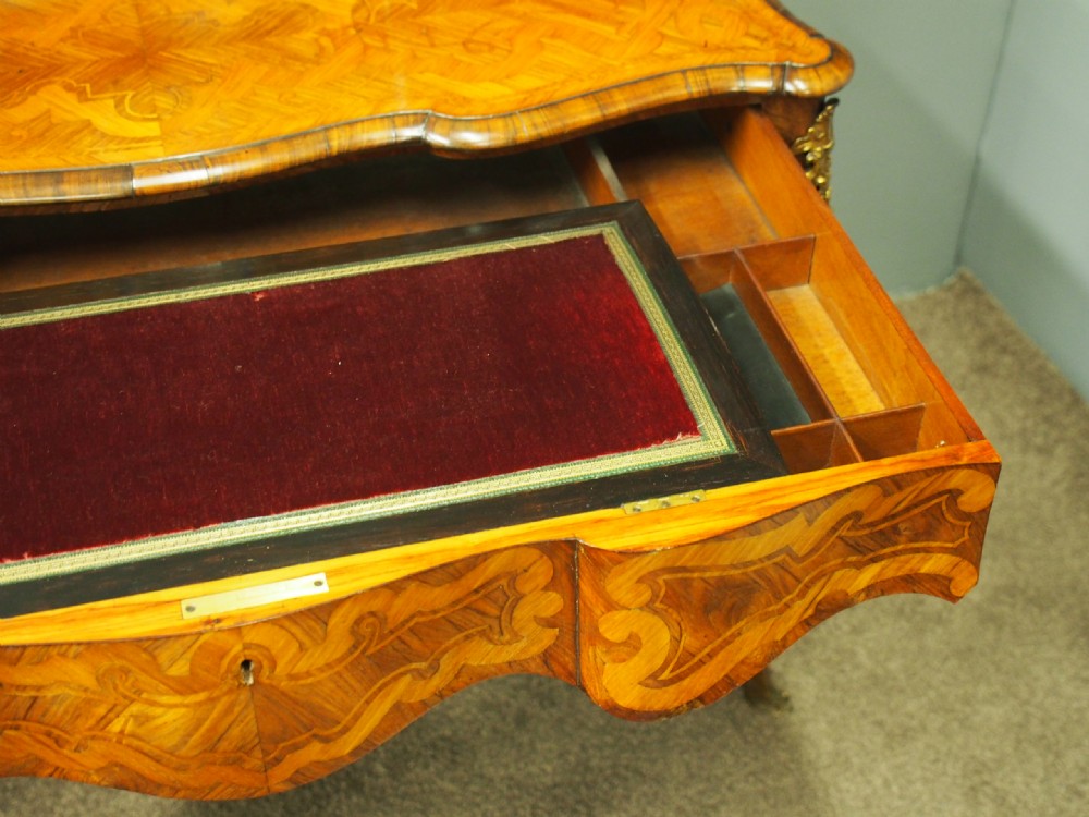 A French Rococo Revival ladies writing desk featuring intricate wood marquetry, gilt-bronze mounts, cabriole legs, and a central cabinet door set with a hand-painted porcelain plaque. View XIV