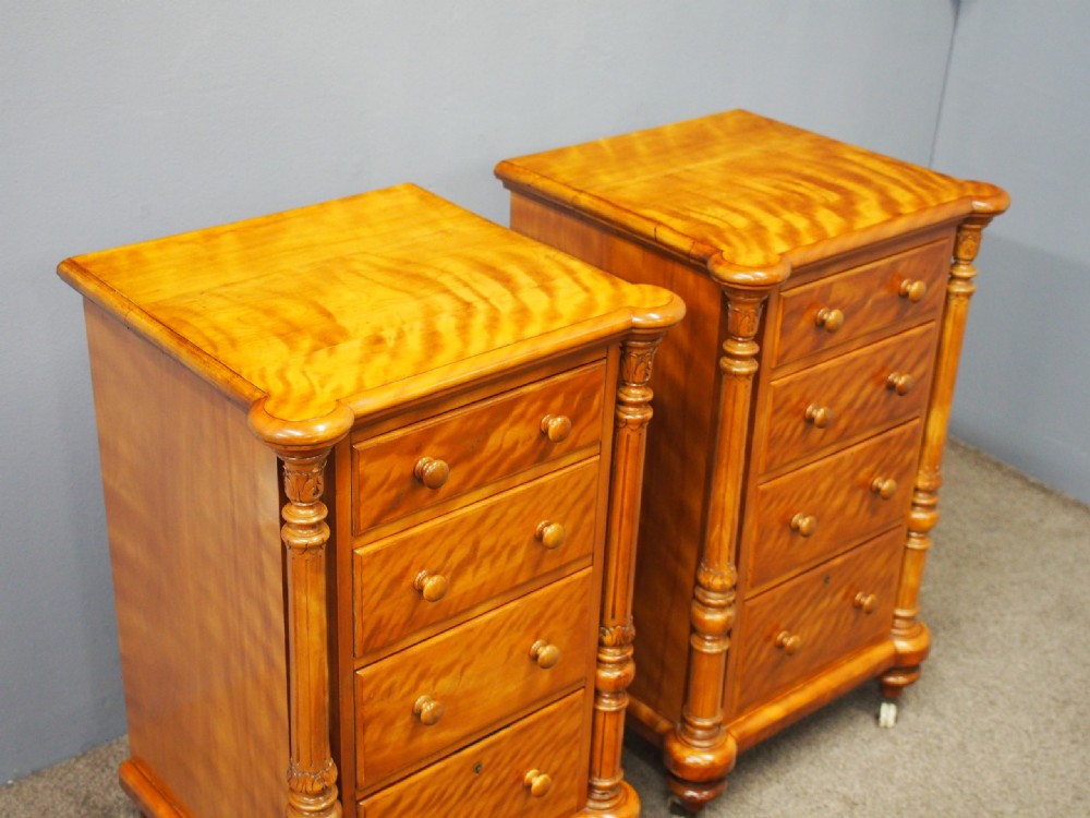 A pair of Victorian satin birch pedestal chests featuring four stacked drawers, turned corner columns, wooden knob handles, and castors. View II