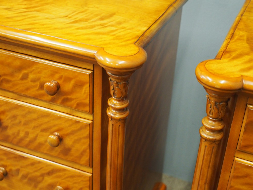 A pair of Victorian satin birch pedestal chests featuring four stacked drawers, turned corner columns, wooden knob handles, and castors. View VIII