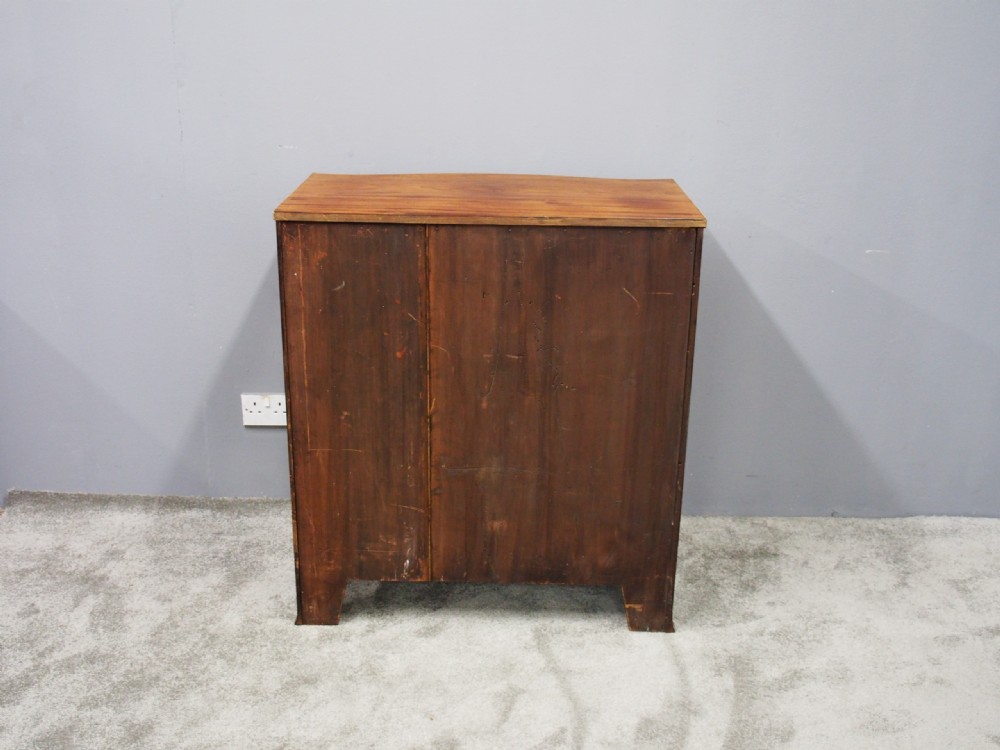 A Hepplewhite style mahogany chest of drawers featuring a serpentine front, four graduated drawers with cast brass handles, boxwood string inlay, and splayed bracket feet. View XII