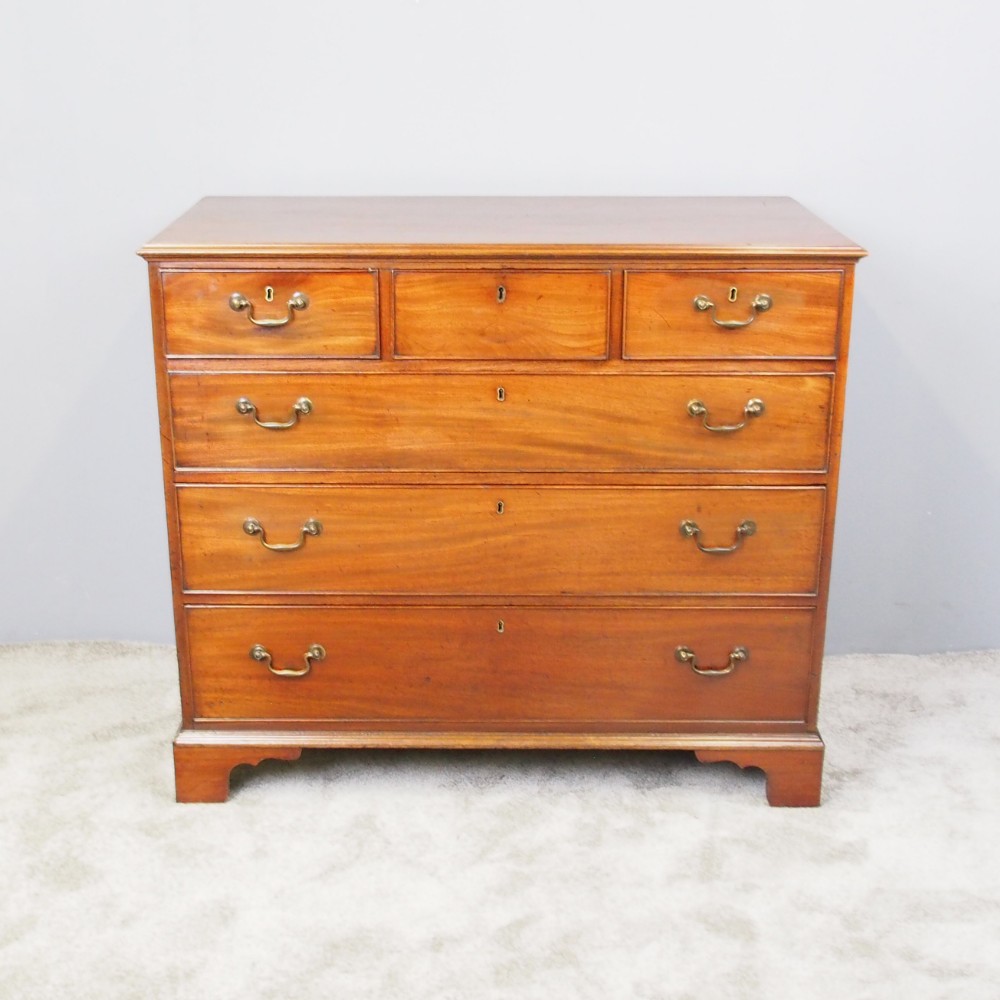 A George III Dumfries House style mahogany chest of drawers featuring three short top drawers over three long graduated drawers with brass swan-neck handles and bracket feet.