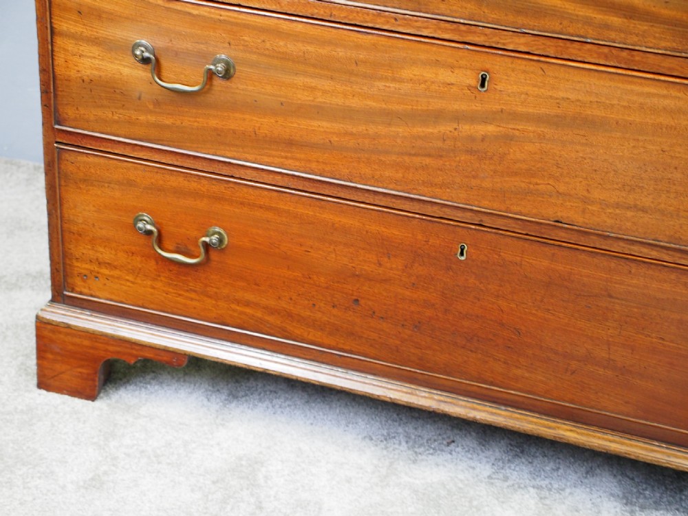 A George III Dumfries House style mahogany chest of drawers featuring three short top drawers over three long graduated drawers with brass swan-neck handles and bracket feet. View IV