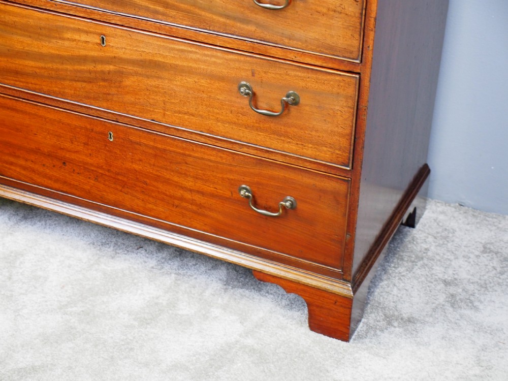 A George III Dumfries House style mahogany chest of drawers featuring three short top drawers over three long graduated drawers with brass swan-neck handles and bracket feet. View V