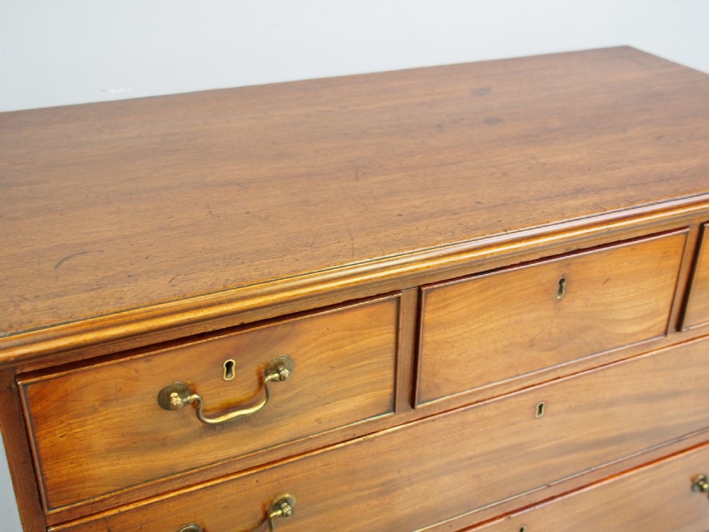 A George III Dumfries House style mahogany chest of drawers featuring three short top drawers over three long graduated drawers with brass swan-neck handles and bracket feet. View VI