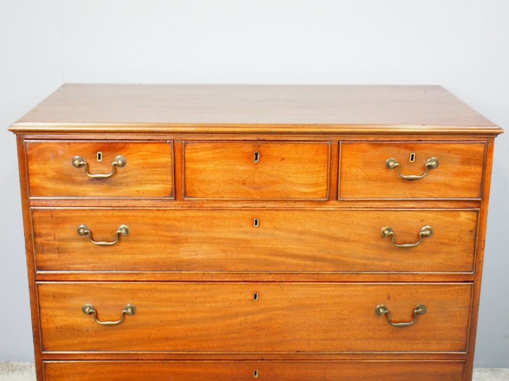 A George III Dumfries House style mahogany chest of drawers featuring three short top drawers over three long graduated drawers with brass swan-neck handles and bracket feet. View IX