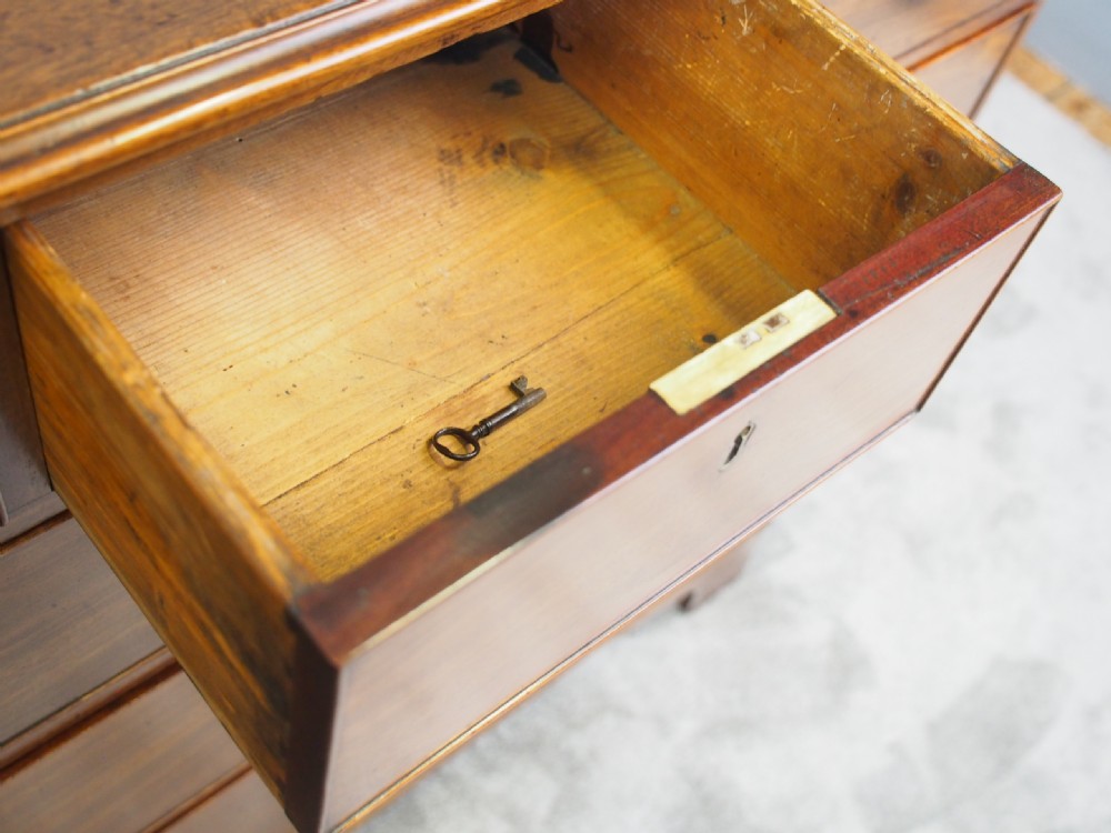 A George III Dumfries House style mahogany chest of drawers featuring three short top drawers over three long graduated drawers with brass swan-neck handles and bracket feet. View X