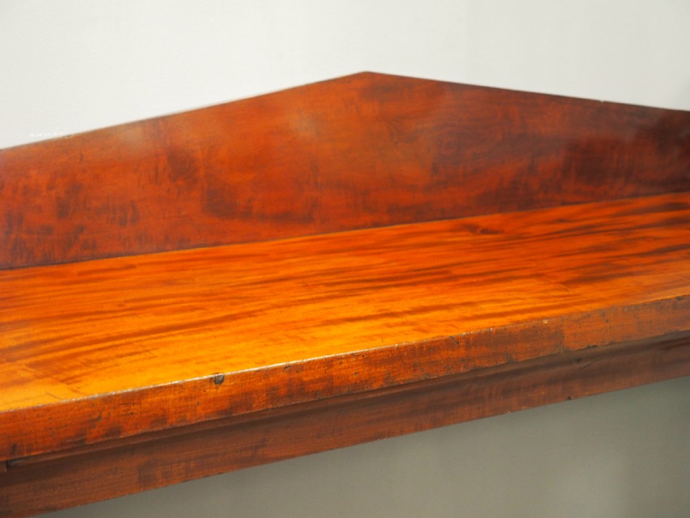 A Scottish Regency mahogany serving table featuring a raised shaped gallery back with carved round scroll details and curved front legs. View IV