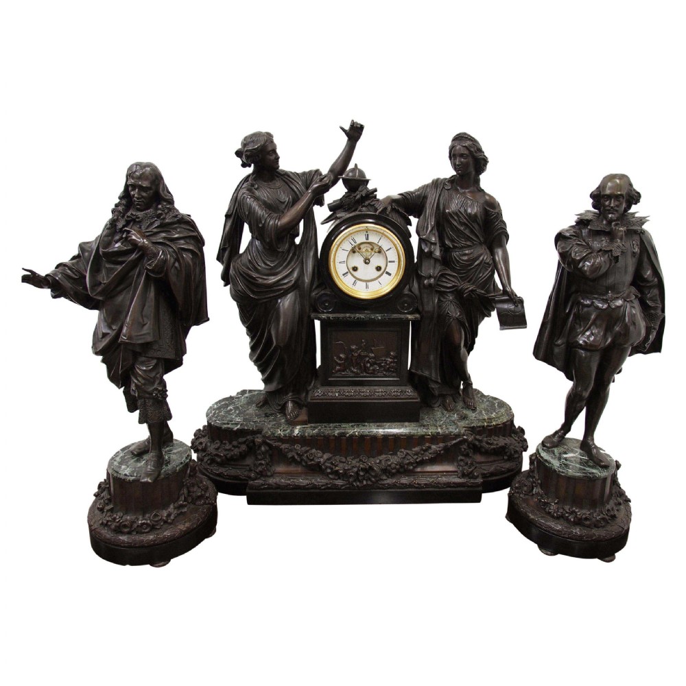 A three-piece French antique clock garniture featuring a central mantel clock flanked by classical female figures and two standalone bronze male sculptures on dark marble bases.