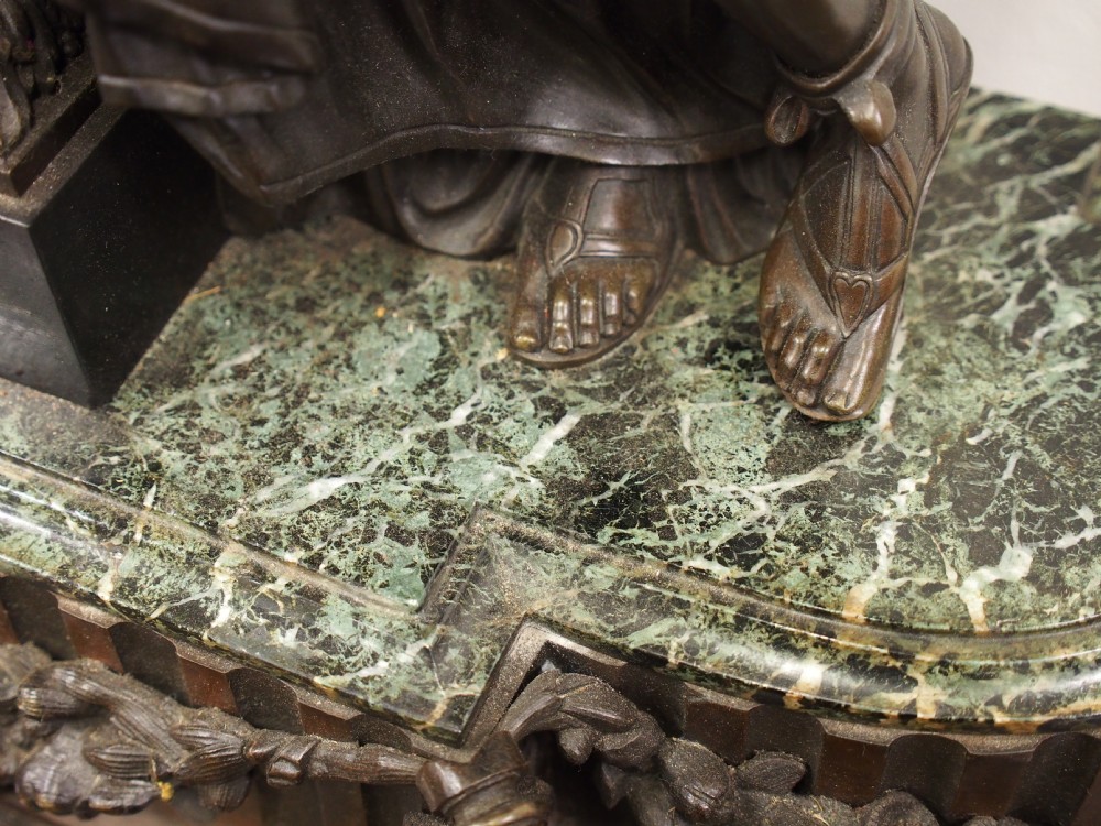 A three-piece French antique clock garniture featuring a central mantel clock flanked by classical female figures and two standalone bronze male sculptures on dark marble bases. View XVI