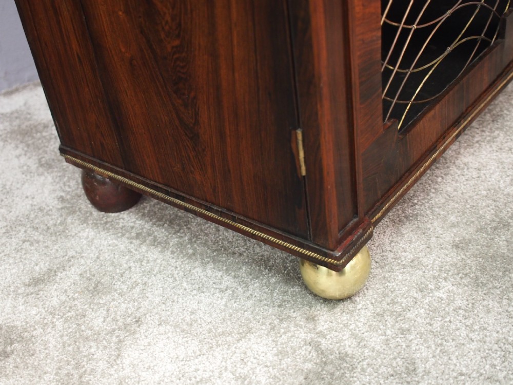 An antique Regency rosewood secretaire chiffonier featuring an upper tier shelf with S-scroll supports, brass mounts, and double doors with brass wire grilles. View XII