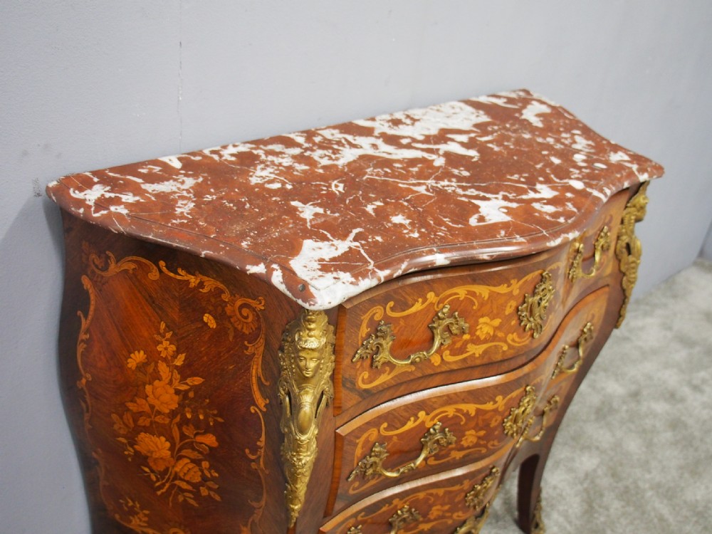 An antique French Louis XV style bombe commode crafted from kingwood marquetry with ornate ormolu mounts and a contoured marble top. View X