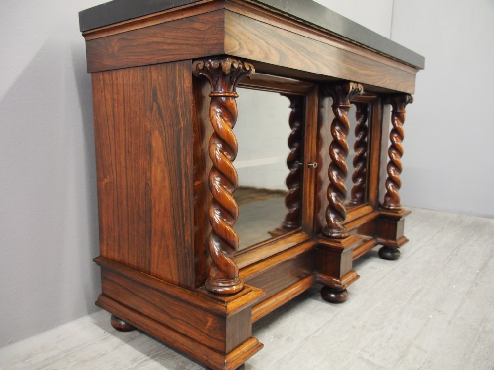A dark William IV rosewood side cabinet featuring a geometric specimen marble top, barley twist support columns, and two glass door panels. View XIV