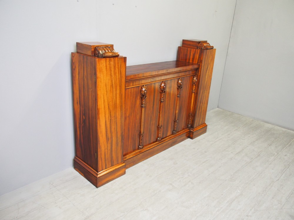 A Regency period goncalo alves wood cabinet featuring two outer pedestal towers and carved leaf motif pilasters along the central panel. View III