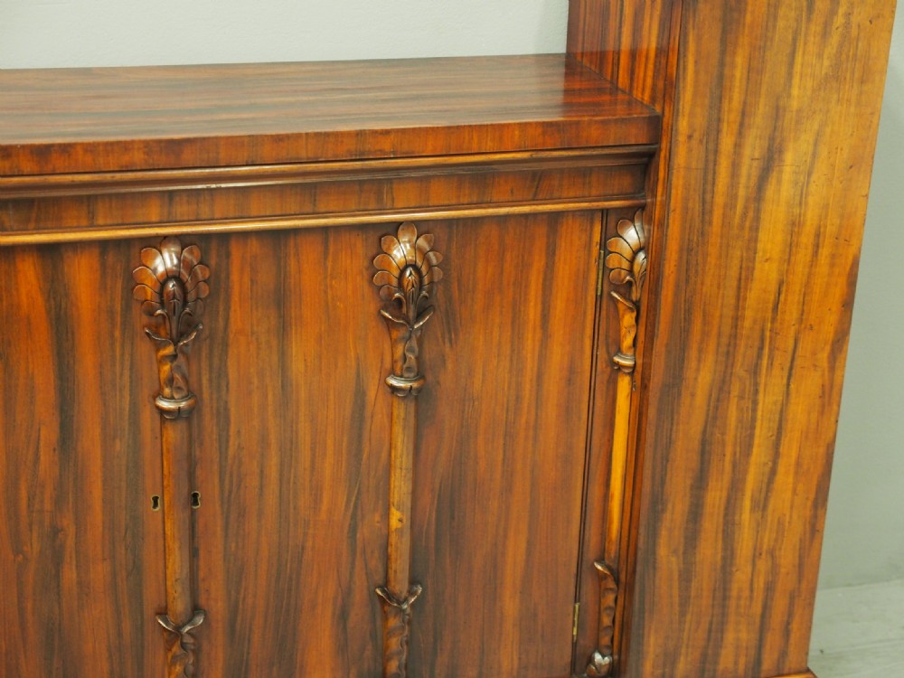 A Regency period goncalo alves wood cabinet featuring two outer pedestal towers and carved leaf motif pilasters along the central panel. View VIII