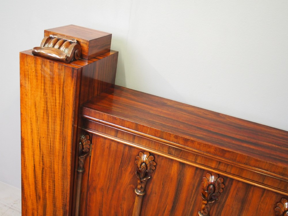A Regency period goncalo alves wood cabinet featuring two outer pedestal towers and carved leaf motif pilasters along the central panel. View IX
