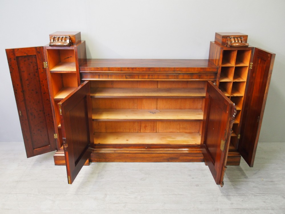 A Regency period goncalo alves wood cabinet featuring two outer pedestal towers and carved leaf motif pilasters along the central panel. View XI