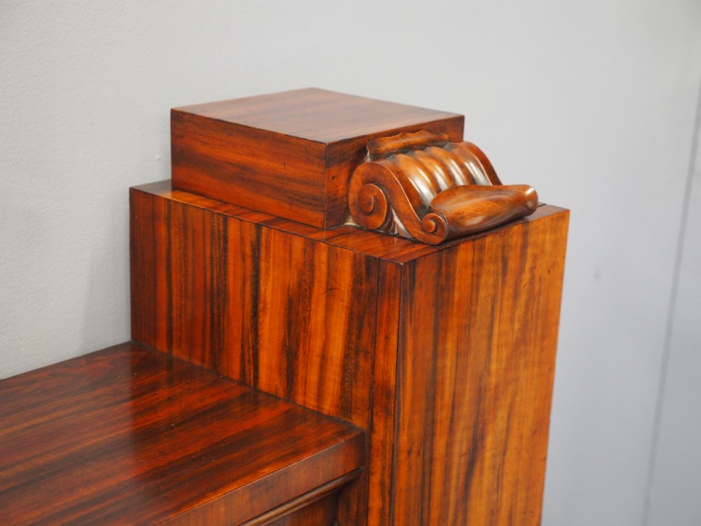 A Regency period goncalo alves wood cabinet featuring two outer pedestal towers and carved leaf motif pilasters along the central panel. View XV
