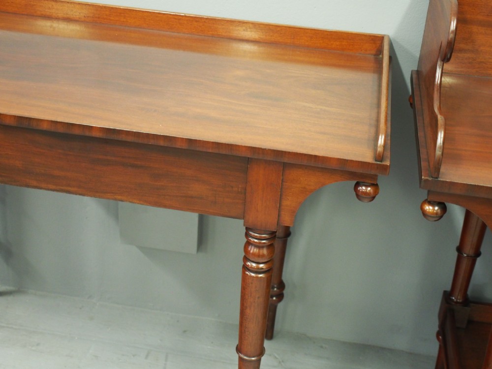 A matched pair of mahogany tables featuring turned legs, with one table incorporating a high gallery splashback and a lower tier shelf. View VIII