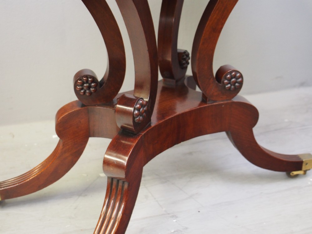 A Regency mahogany fold-over tea table featuring bead moulding along the frieze, set on scrolled supports and reeded splayed legs with brass castors. View XII