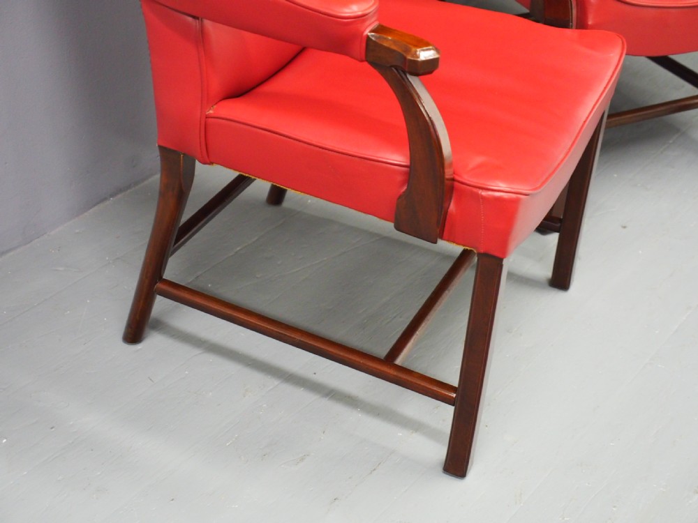 A pair of red leather armchairs with dark mahogany frames and padded armrests. View VIII