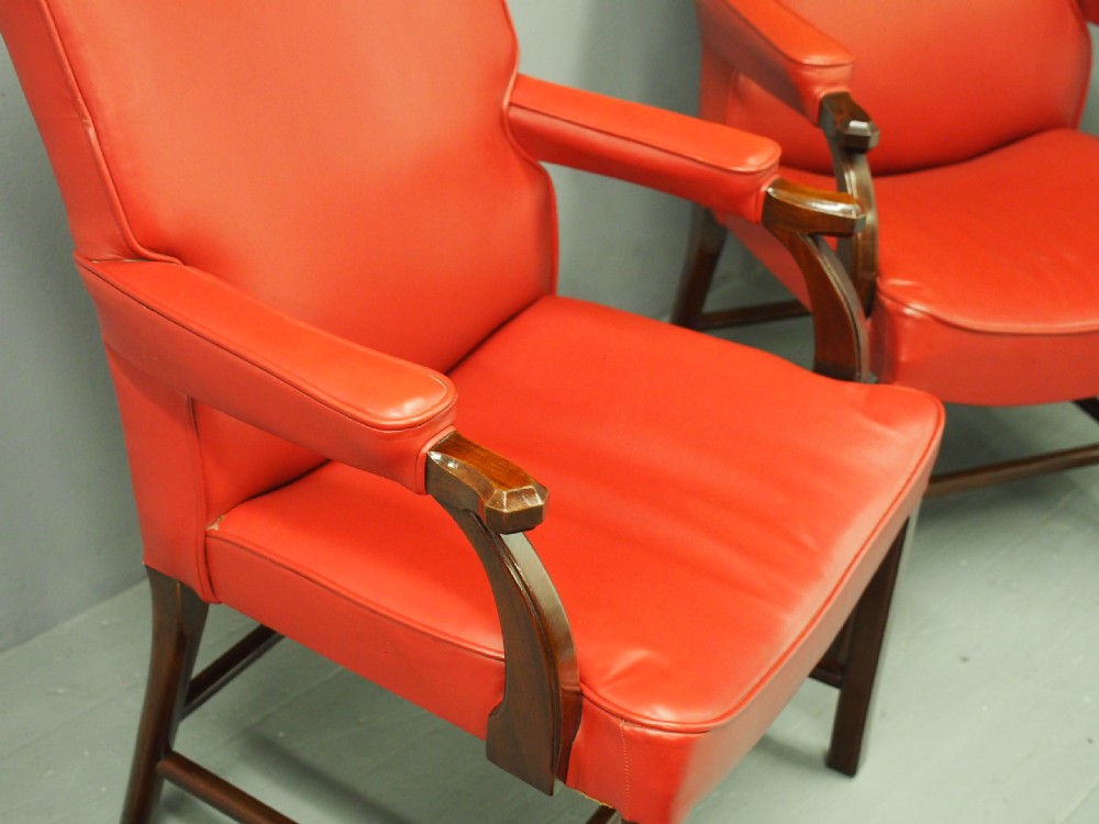 A pair of red leather armchairs with dark mahogany frames and padded armrests. View IX
