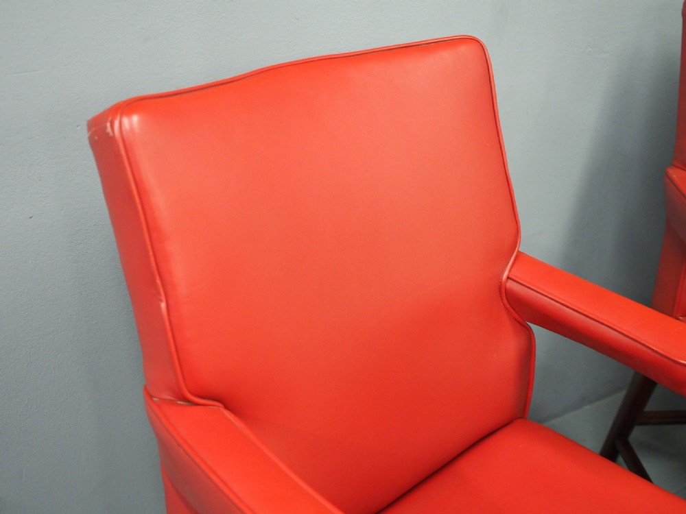 A pair of red leather armchairs with dark mahogany frames and padded armrests. View XI