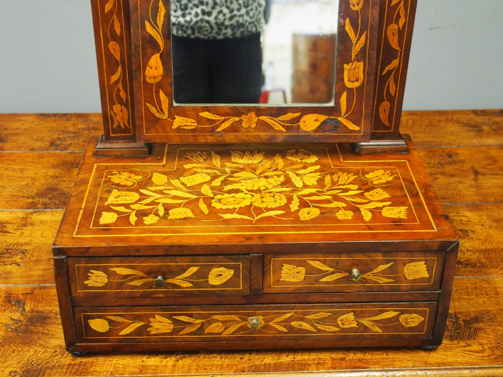 A Dutch marquetry toilet mirror with floral wood inlay, a pivoting rectangular frame, and a base featuring small drawers. View V