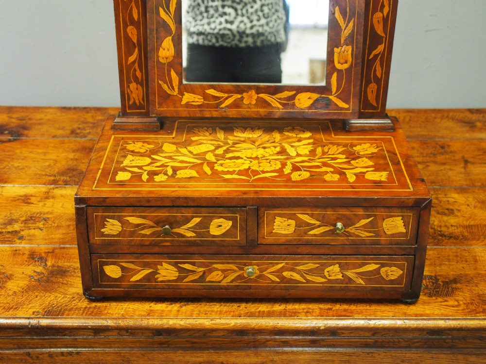 A Dutch marquetry toilet mirror with floral wood inlay, a pivoting rectangular frame, and a base featuring small drawers. View XII