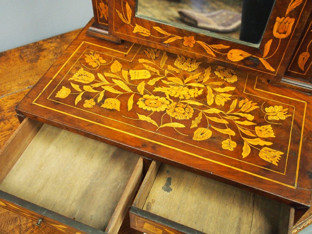 A Dutch marquetry toilet mirror with floral wood inlay, a pivoting rectangular frame, and a base featuring small drawers. View XVII