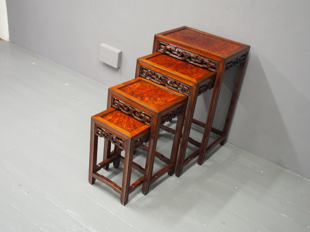A set of four graduated Chinese Hongmu tables featuring figured burrwood inset tops and carved openwork fretwork aprons. View II