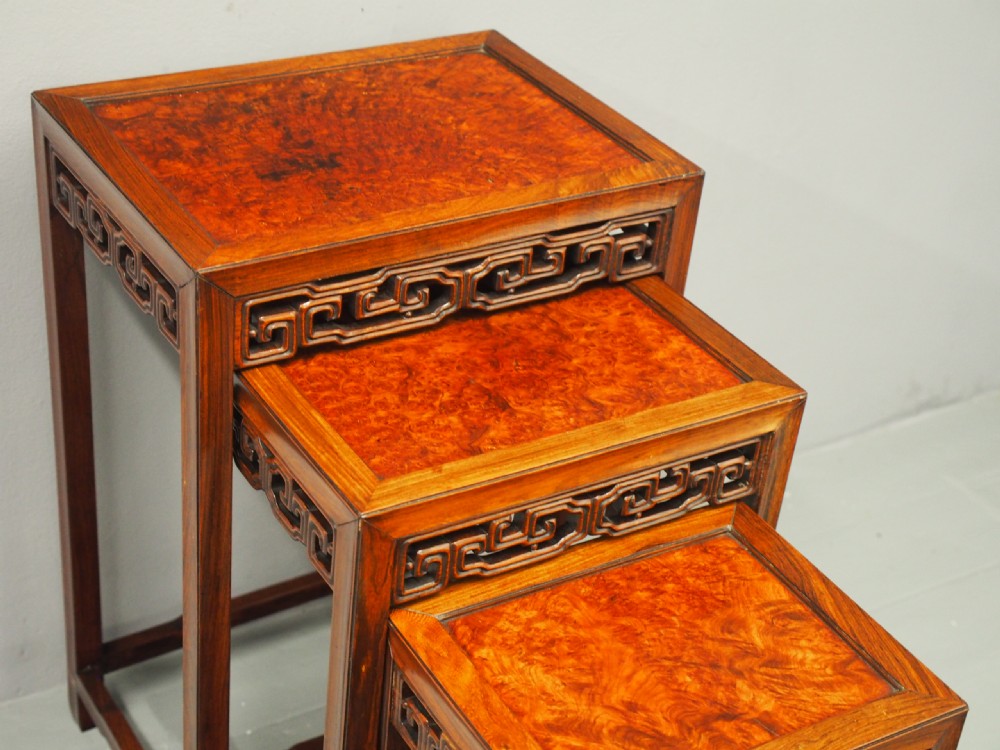 A set of four graduated Chinese Hongmu tables featuring figured burrwood inset tops and carved openwork fretwork aprons. View III