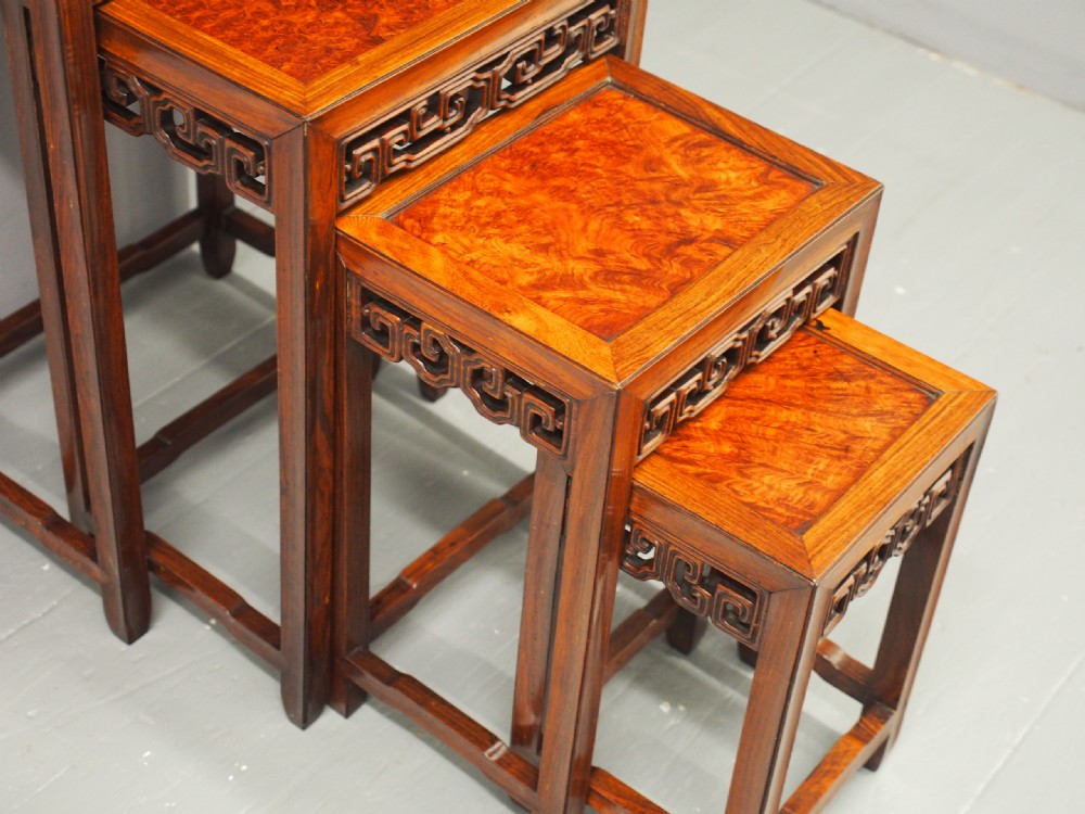 A set of four graduated Chinese Hongmu tables featuring figured burrwood inset tops and carved openwork fretwork aprons. View IV
