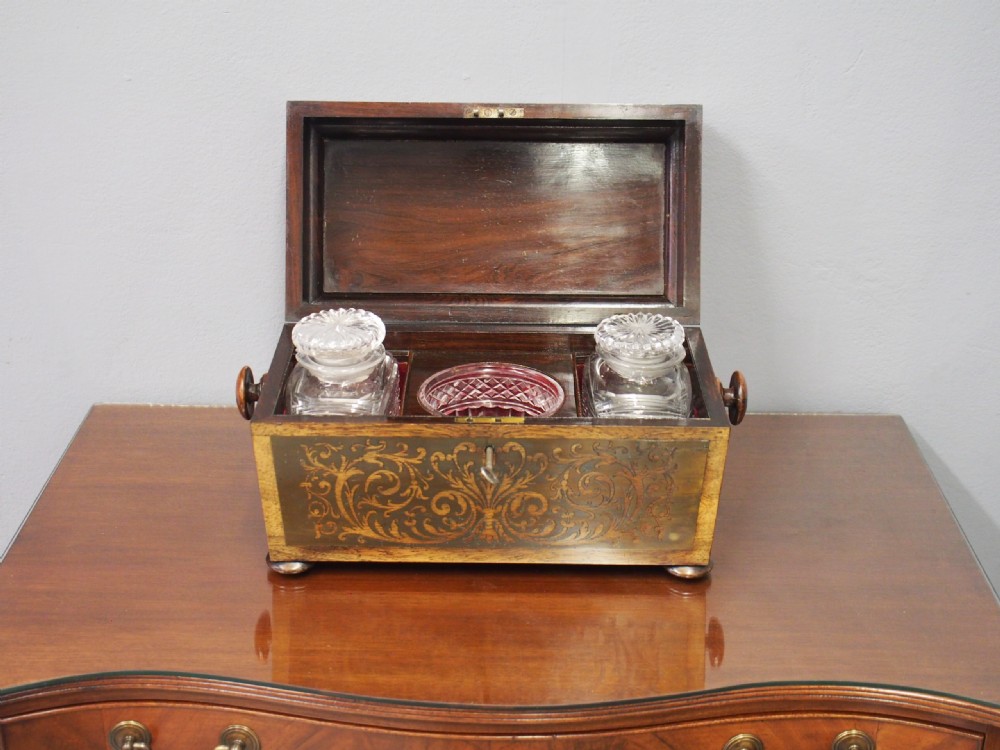 An antique dark rosewood tea caddy featuring intricate brass scrollwork inlay, side wooden ring handles, and turned bun feet. View II