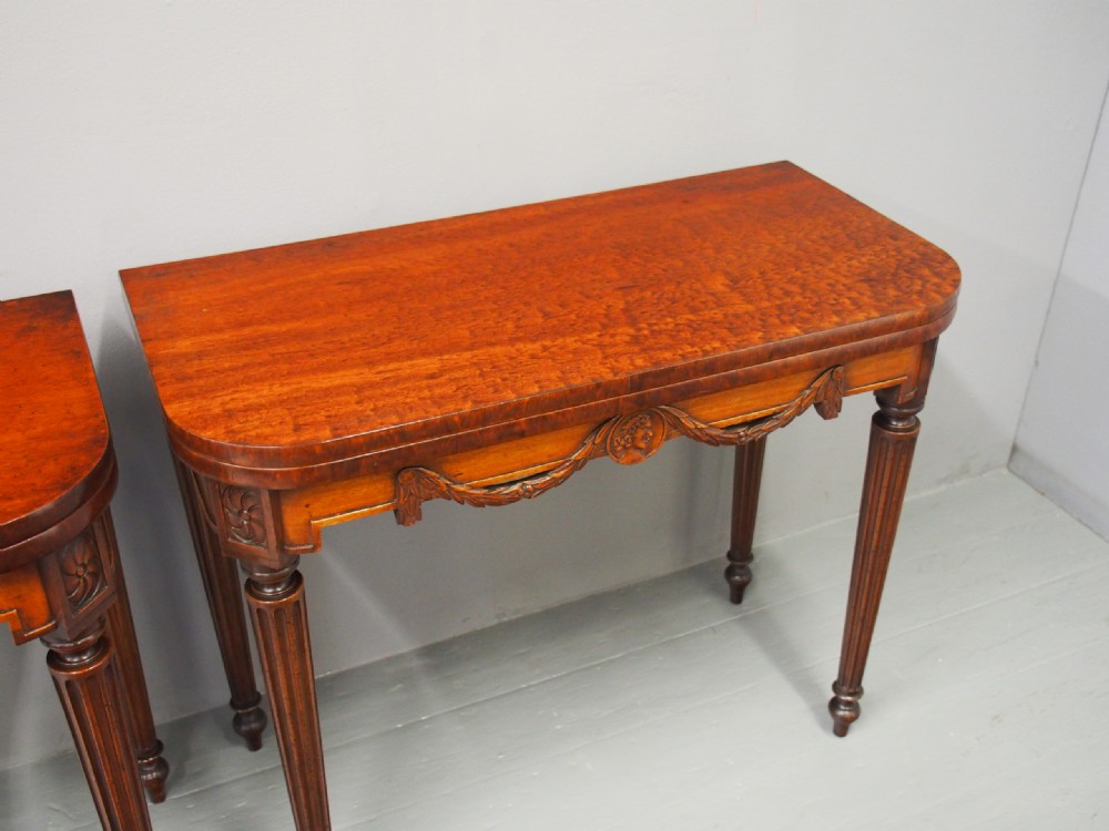A pair of William IV mahogany foldover card tables featuring fluted legs, carved floral swags, and rectangular hinged tops. View IX