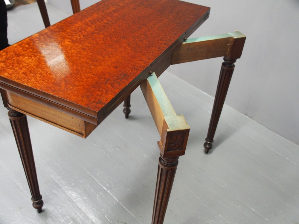 A pair of William IV mahogany foldover card tables featuring fluted legs, carved floral swags, and rectangular hinged tops. View XV