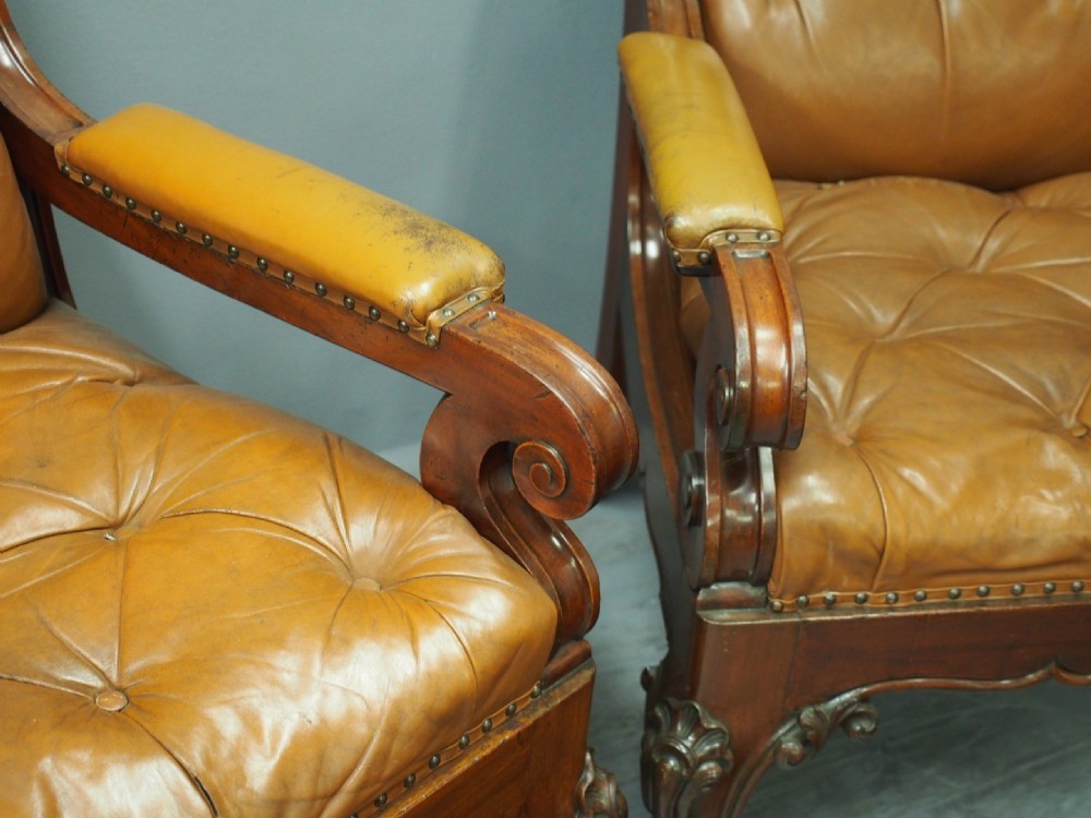 A pair of George IV mahogany armchairs upholstered in button-backed tan leather with carved cabriole legs and brass studding. View VII