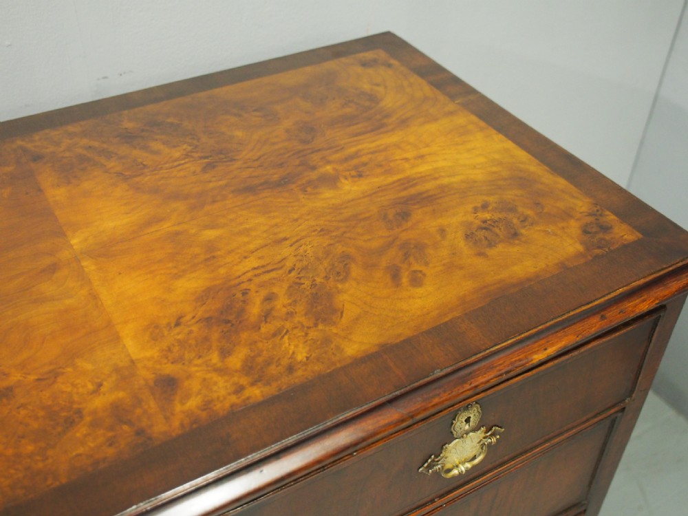 An 18th-century style George III walnut chest of drawers featuring two short over three long drawers with brass handles and escutcheons, set on turned ball feet. View III